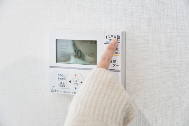 浴室リモコンの自動ボタンを押す手